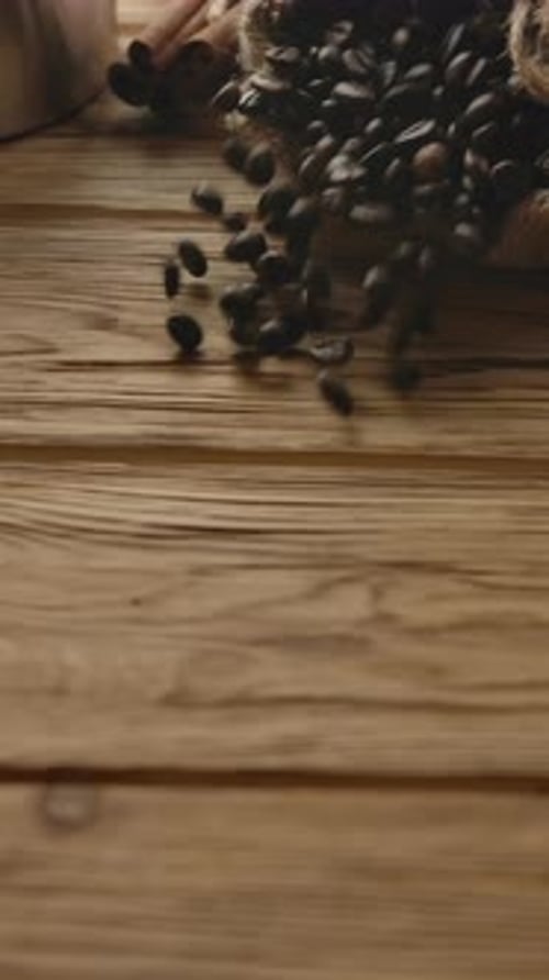 Coffee Beans Spill onto Rustic Table