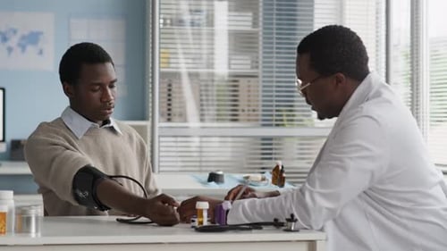 Doctor Checking Patient Blood Pressure in Office
