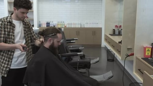 Barber Trims Hair in Modern Barbershop