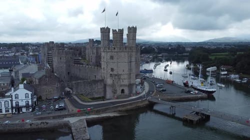 Ancient Caernarfon castle Welsh harbour town aerial view medieval waterfront landmark close left dol