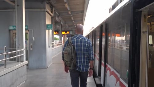 City Dweller with a Backpack Walking Along Metro Train on the Platform An Adult Heading to Work