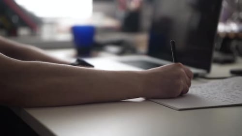 Mann schreibt Ideen, während er am Laptop arbeitet