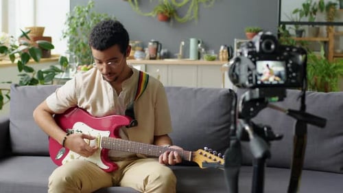 Man Plays Electric Guitar and Records Video at Home