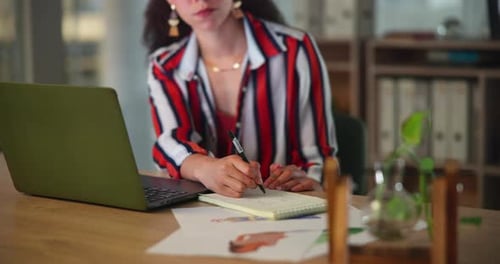 Hands, laptop and business woman writing in notebook at office for planning