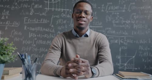 Young Adult Explains Math at His Desk