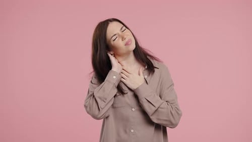 Brunette Woman Massaging Stiff Neck in Studio