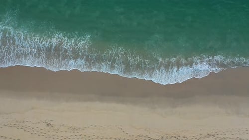 Beach top view with wave foam.