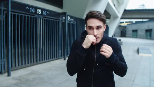 Young Man Boxing in Urban Street in . Portrait of Kickboxer
