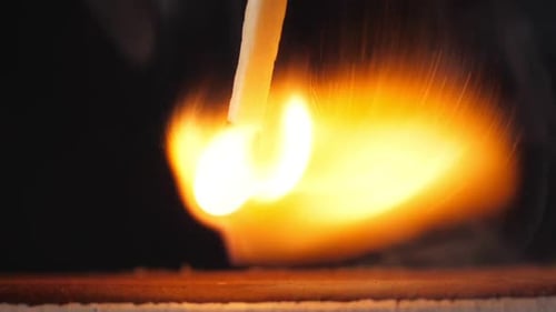 Burning Match Ignites with Bright Flame on Dark