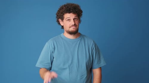 Happy man showing ok gesture isolated on blue background in studio