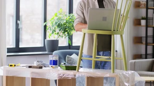 Hispanic man prepares antique bentwood Vienna chair for home restoration project