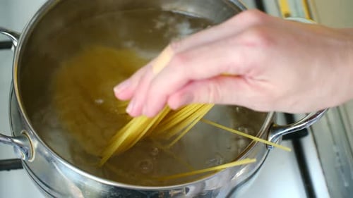 Person Cooking Spaghetti in a Pot of Boiling Water