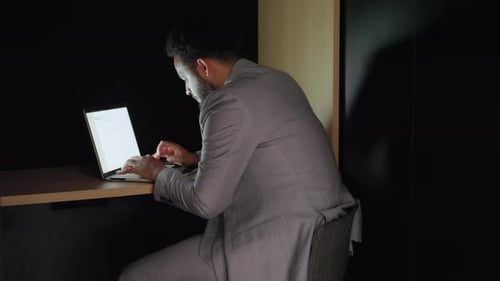Un homme d'affaires afro-américain concentré travaille activement dans un espace de bureau contemporain