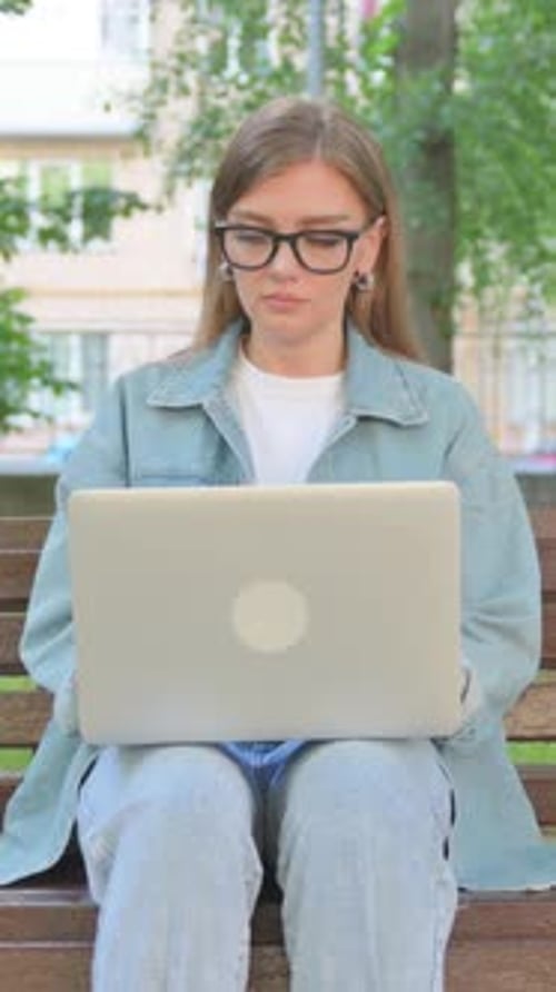 Woman Works on Laptop in Urban Park Setting