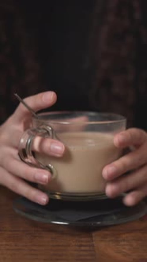Girl Stirring Hot Coffee On Wooden Table And Then Smelled It Close Up