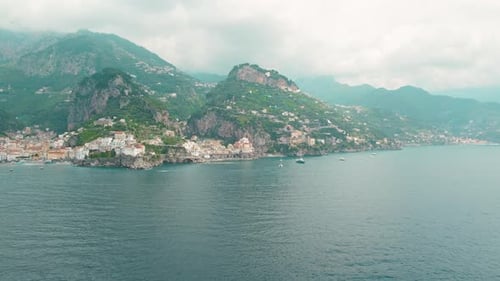 Wide view of coast, highlighting the coastal towns of Atrani and Amalfi nestled among towering mount