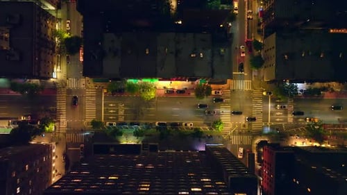 Beautifully lit streets of night New York. Lots of cars going along the roads and passing crossroads