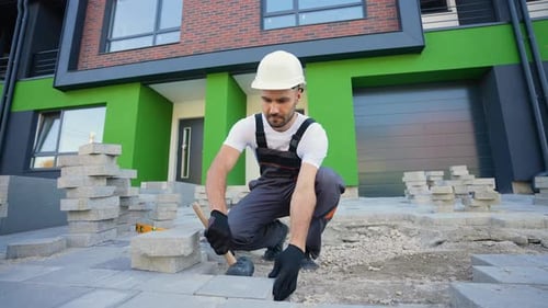 Man Laying Stone Pavers on Driveway
