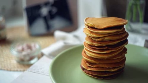 Stack of Pancakes with Jam on a Green Plate
