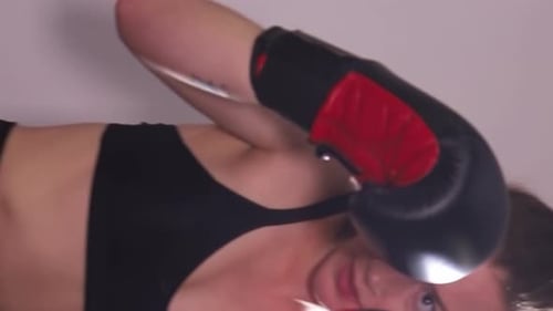 Woman Working Out Boxing Punching Bag in Gym