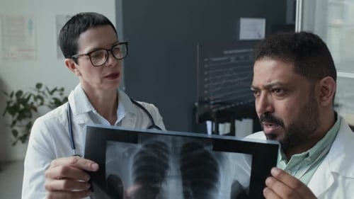 Female Doctor Discussing Chest-X-Ray with Colleague at Work in Clinic