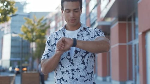 Closeup Young Busy Enterpreneur Walking in the Street Looking Tapping on Little Wristwatch Screen