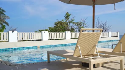 empty bed pool around swimming pool with sea background - holidays and vacations concept