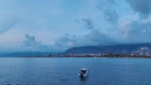 Aerial Video of Luxury Yacht Speeding Across the Open Blue Sea Under Dramatic Cloudy Sky Creating