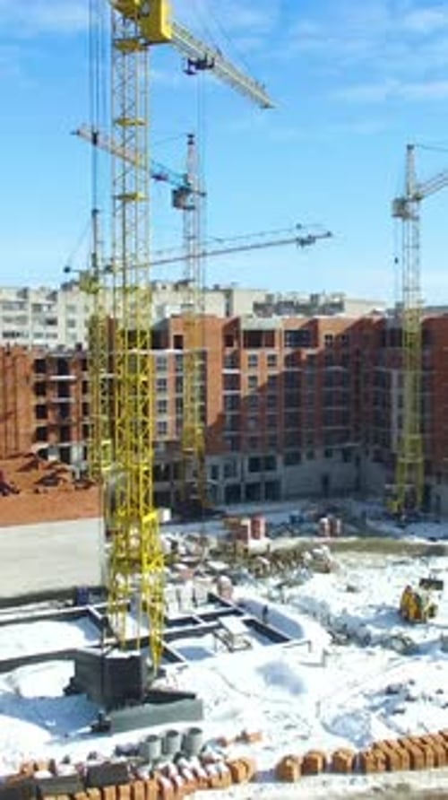 New house construction. Large apartment buildings construction in new district among houses