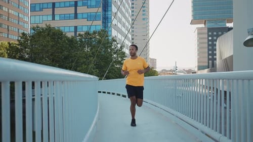 Man Jogging on a Bridge in the City