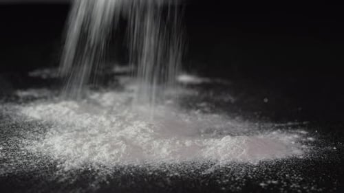 White Powder Poured on Black Surface Close Up