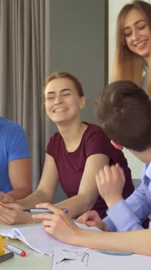 Dynamic Young Professionals Collaborating Over a Laptop in a Modern Office