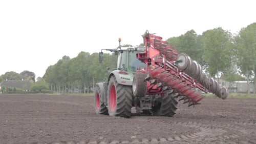 Tractor with big plow standing on field