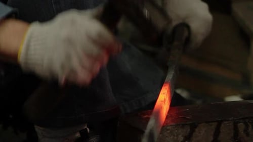 Blacksmith Forging Hot Metal with Hammer
