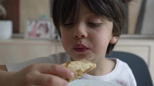 Young boy enjoys a tasty pancake, focusing on the flavor with a serious expression, highlighting a