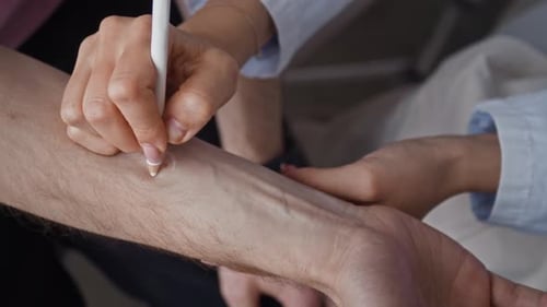 Dermatólogo marca una lesión cutánea durante el examen