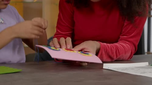 Closeup of Child Hands with Needle and Threads Sewing DIY Kids Bag