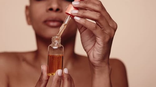 Woman Holds Serum Bottle and Dropper Close Up