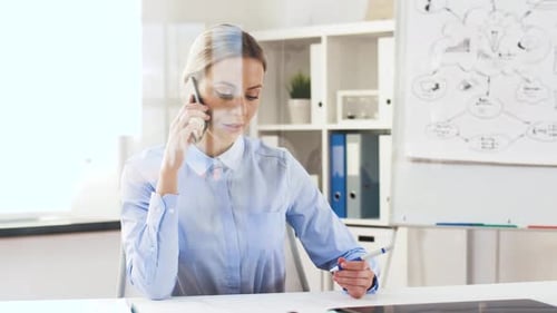 Happy businesswoman talking on smartphone at office through glass wall