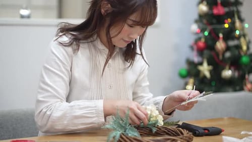 Young Woman Creating Festive Christmas Wreath