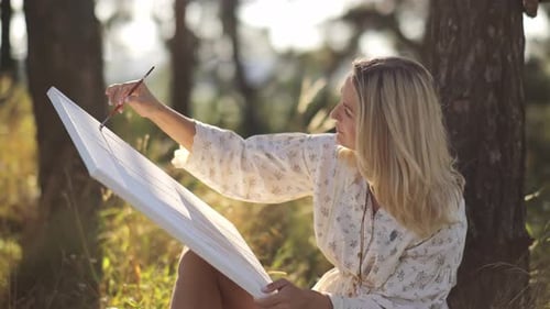 A Beautiful Female Artist Created a Painting Using Acrylic Paints The Artist Works Outdoors in Sunny