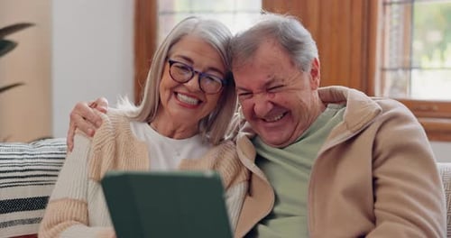 Happy Senior Couple Laughing at Tablet Together