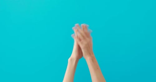Weibliche anmutige Hände applaudieren auf einheitlichem blauem Hintergrund