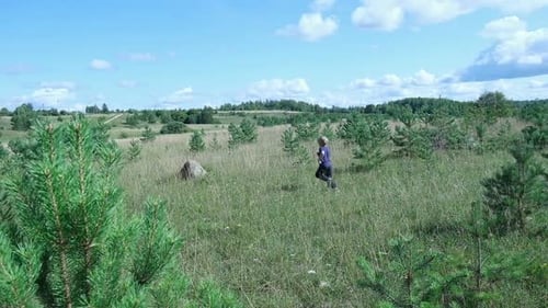 Exploring Nature a Hiker with Backpack Strolling Through a Beautiful Field Beneath Vast Blue Sky