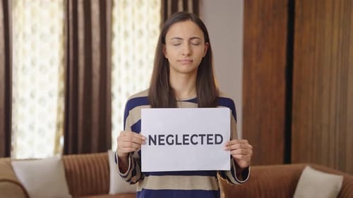 Sad Indian woman holding NEGLECTED banner