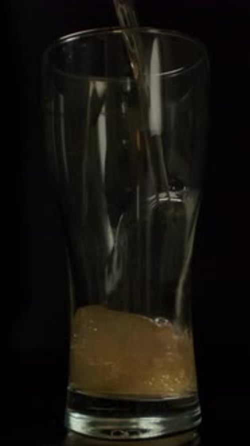 Beer Pouring into a Glass on Black Background