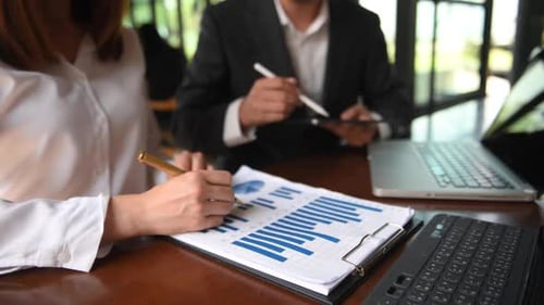 Business Colleagues Reviewing Charts and Graphs in Office