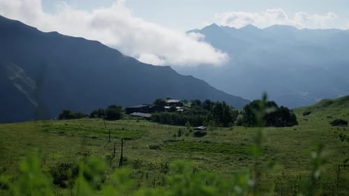 Remote Buildings Surrounded By Lush Fields and Mountain Silhouettes Secluded Homestead Nestled in