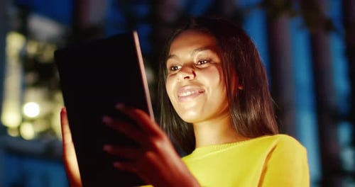 Close Up of Beautiful Happy Young Brunette Woman Using Tablet Computer and Scrolling on Screen Late
