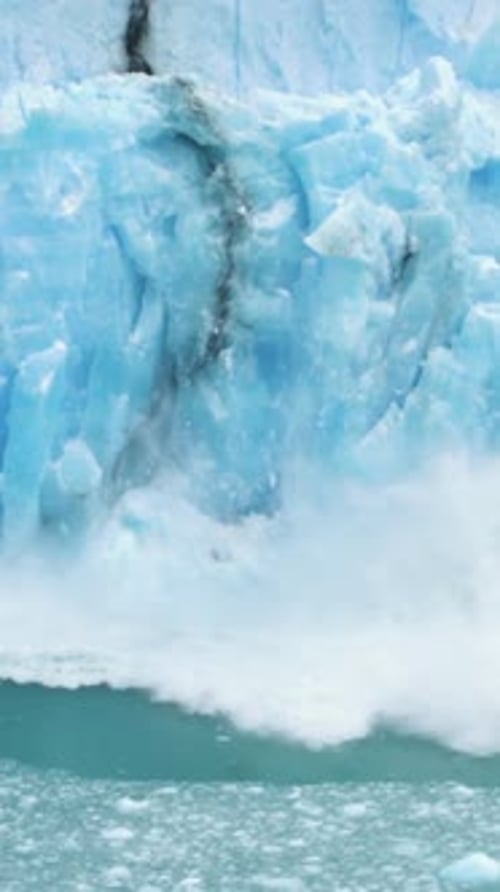 Vertical View, Glacier Ice Collapse Into Ocean Water, Close Up. Global Warming and Climate Change Co